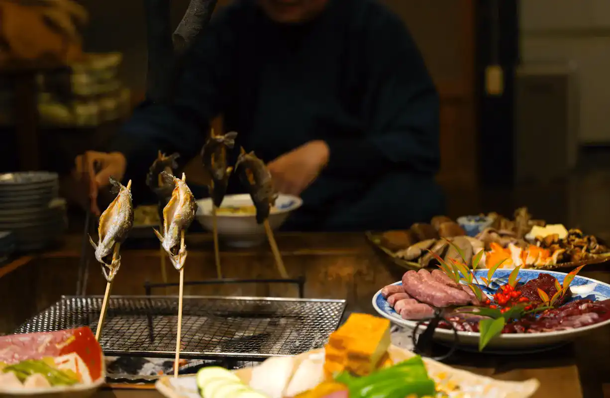 囲炉裏を囲んで夕食を食べる様子